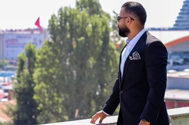 Ömer Kaya im dunklen Anzug mit Sonnenbrille auf einer Terrasse über Bischofsheim