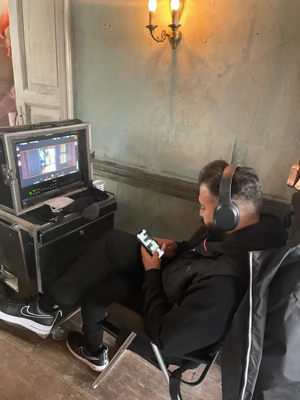 Ömer Kaya mit Kopfhörern am Monitorwagen beim Dreh von Osman Sekiz