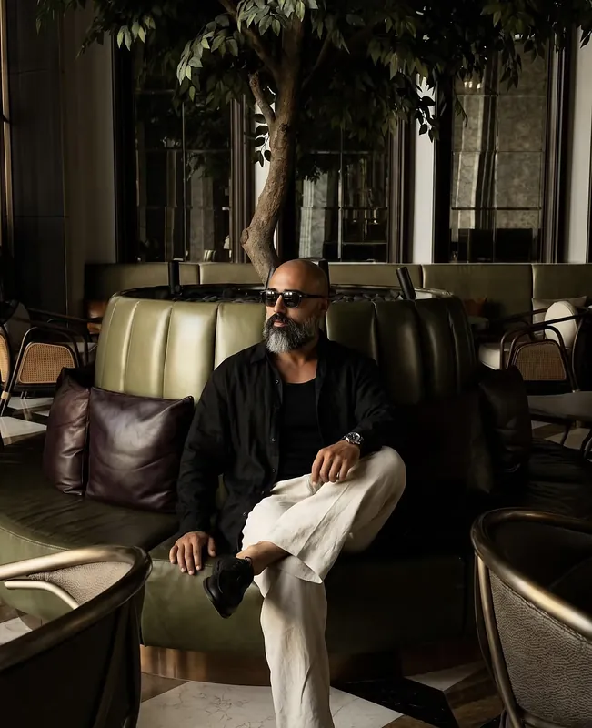 Ömer Kaya mit Sonnenbrille auf einer Ledercouch in einer Hotellounge